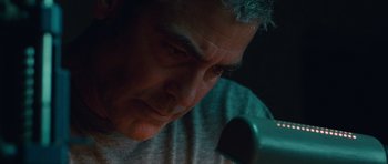 Movie still from “The American” (2010), directed by Anton Corbijn – A man's face as he looks down at a microphone; Close Up shot, Low angle