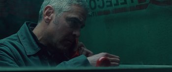 Movie still from “The American” (2010), directed by Anton Corbijn – A man sitting in front of a red phone; Close Up shot, Low angle