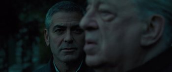 Movie still from “The American” (2010), directed by Anton Corbijn – Two older men looking at each other in the dark; Close Up shot, Over the shoulder angle