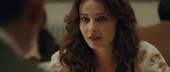 Movie still from “The American” (2010), directed by Anton Corbijn – A person with long hair; Close Up shot, Over the shoulder angle