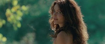 Movie still from “The American” (2010), directed by Anton Corbijn – A beautiful woman with long brown curly hair; Close Up shot, Over the shoulder angle