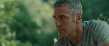Movie still from “The American” (2010), directed by Anton Corbijn – A person with grey hair; Close Up shot, Over the shoulder angle