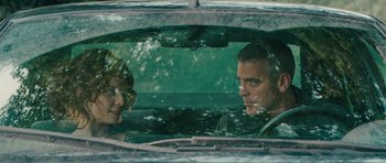 Movie still from “The American” (2010), directed by Anton Corbijn – Two people in a car looking out the window; Close Up shot, Over the shoulder angle