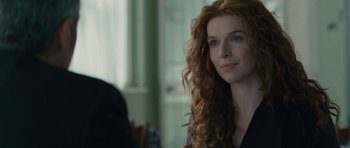 Movie still from “The American” (2010), directed by Anton Corbijn – A person with curly hair; Close Up shot, Over the shoulder angle