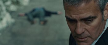 Movie still from “The American” (2010), directed by Anton Corbijn – A person in a suit on the ground; Close Up shot, Low angle