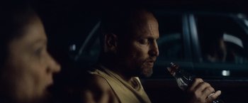 Movie still from “Out of the Furnace” (2013), directed by Scott Cooper – A man sitting in a car holding a glass of wine; Close Up shot, Over the shoulder angle