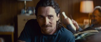 Movie still from “Out of the Furnace” (2013), directed by Scott Cooper – A person with long hair; Close Up shot, Over the shoulder angle