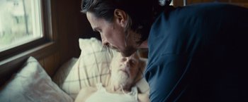 Movie still from “Out of the Furnace” (2013), directed by Scott Cooper – A man standing next to an older man in a hospital bed; Close Up shot, Over the shoulder angle