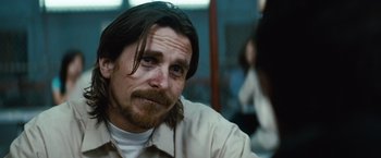 Movie still from “Out of the Furnace” (2013), directed by Scott Cooper – A person with long hair and a beard; Close Up shot, Over the shoulder angle