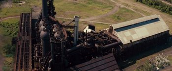 Movie still from “Out of the Furnace” (2013), directed by Scott Cooper – An aerial view of an industrial area with machinery; Extreme Wide shot, High angle