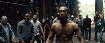 Movie still from “Out of the Furnace” (2013), directed by Scott Cooper – A group of men walking down a street; Medium shot, High angle