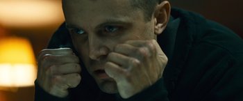 Movie still from “Out of the Furnace” (2013), directed by Scott Cooper – A person holding a cell phone up to their face; Close Up shot, Low angle
