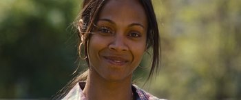 Movie still from “Out of the Furnace” (2013), directed by Scott Cooper – A person smiling for the camera; Close Up shot, Over the shoulder angle