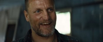Movie still from “Out of the Furnace” (2013), directed by Scott Cooper – A person with a beard smiling; Close Up shot, Low angle