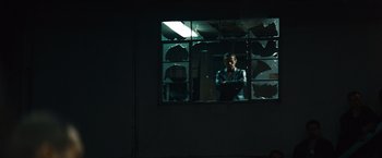 Movie still from “Out of the Furnace” (2013), directed by Scott Cooper – A man standing in front of a window at night; Wide shot, Low angle