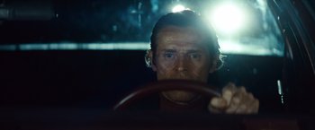 Movie still from “Out of the Furnace” (2013), directed by Scott Cooper – A man sitting in the drivers seat of a car at night; Close Up shot, Low angle