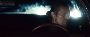 Movie still from “Out of the Furnace” (2013), directed by Scott Cooper – A person in a car; Close Up shot, Over the shoulder angle