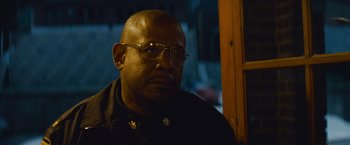 Movie still from “Out of the Furnace” (2013), directed by Scott Cooper – A man wearing glasses and a black jacket; Close Up shot, Low angle