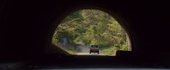 Movie still from “Out of the Furnace” (2013), directed by Scott Cooper – A car driving down a road through a tunnel; Extreme Wide shot, Low angle