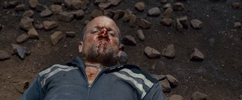 Movie still from “Out of the Furnace” (2013), directed by Scott Cooper – A person laying on the ground covered in blood; Close Up shot, Overhead angle