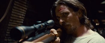 Movie still from “Out of the Furnace” (2013), directed by Scott Cooper – A person holding a rifle; Close Up shot, Over the shoulder angle