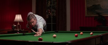 Movie still from “The American President” (1995), directed by Rob Reiner – A man is playing pool on a pool table; Medium shot, Over the shoulder angle