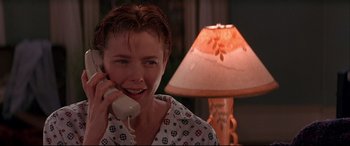 Movie still from “The American President” (1995), directed by Rob Reiner – A woman talking on a phone in front of a lamp; Close Up shot, Low angle