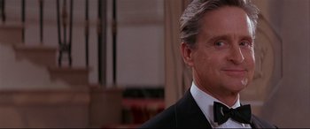 Movie still from “The American President” (1995), directed by Rob Reiner – A man in a suit and bow - tie is smiling for the camera; Close Up shot, Over the shoulder angle
