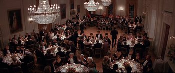 Movie still from “The American President” (1995), directed by Rob Reiner – A large group of people sitting at tables in a room; Extreme Wide shot, High angle