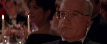 Movie still from “The American President” (1995), directed by Rob Reiner – An older man wearing glasses sitting next to a woman; Close Up shot, Over the shoulder angle