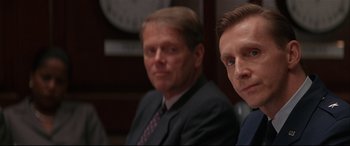 Movie still from “The American President” (1995), directed by Rob Reiner – Two men in suits sitting next to each other in front of a clock; Close Up shot, Over the shoulder angle