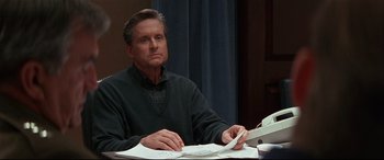 Movie still from “The American President” (1995), directed by Rob Reiner – A man sitting at a table with papers in front of him; Medium shot, Low angle