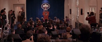Movie still from “The American President” (1995), directed by Rob Reiner – A crowd of people sitting in front of a podium; Wide shot, High angle