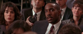 Movie still from “The American President” (1995), directed by Rob Reiner – A man in a suit and tie holding a cell phone; Close Up shot, Over the shoulder angle