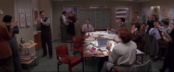 A group of people sitting around a table with papers on it