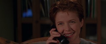 Movie still from “The American President” (1995), directed by Rob Reiner – A woman smiles while talking on a phone; Close Up shot, Low angle