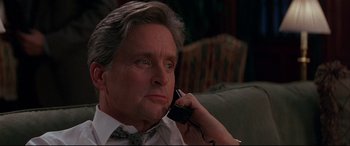 Movie still from “The American President” (1995), directed by Rob Reiner – A man sitting on a couch talking on a phone; Close Up shot, Low angle