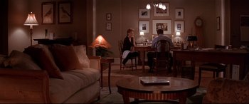 Movie still from “The American President” (1995), directed by Rob Reiner – Two people are sitting at a table in a living room; Wide shot, High angle