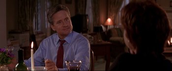 Movie still from “The American President” (1995), directed by Rob Reiner – A man sitting at a table with a glass of wine; Close Up shot, Over the shoulder angle