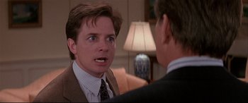 Movie still from “The American President” (1995), directed by Rob Reiner – A man in a suit and tie talking to another man in a suit and tie; Close Up shot, Over the shoulder angle