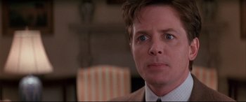 Movie still from “The American President” (1995), directed by Rob Reiner – A person wearing a suit and tie; Close Up shot, Over the shoulder angle