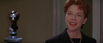 Movie still from “The American President” (1995), directed by Rob Reiner – A person wearing a suit and smiling; Close Up shot, Over the shoulder angle