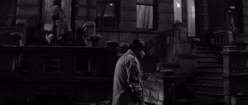 Movie still from “The Apartment” (1960), directed by Billy Wilder – A black and white photo of a man in a hat; Wide shot, High angle