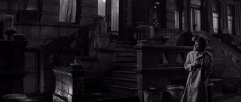 Movie still from “The Apartment” (1960), directed by Billy Wilder – A fire hydrant sits in front of a staircase; Wide shot, Low angle