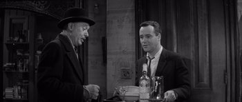 Movie still from “The Apartment” (1960), directed by Billy Wilder – Two men are sitting at a table with a tray of food; Medium shot, Over the shoulder angle