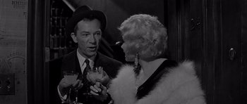 Movie still from “The Apartment” (1960), directed by Billy Wilder – An older man and woman are having a conversation; Close Up shot, Over the shoulder angle