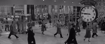 Movie still from “The Apartment” (1960), directed by Billy Wilder – A black and white photo of people walking on a sidewalk; Extreme Wide shot, High angle