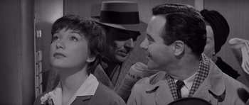 Movie still from “The Apartment” (1960), directed by Billy Wilder – Two men and a woman are talking to each other; Close Up shot, Over the shoulder angle