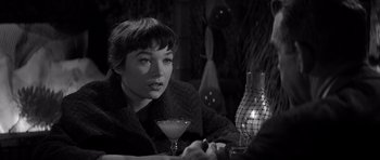 Movie still from “The Apartment” (1960), directed by Billy Wilder – A woman sitting at a table with a glass of wine; Close Up shot, Over the shoulder angle