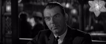 Movie still from “The Apartment” (1960), directed by Billy Wilder – An older man wearing a suit and a tie; Close Up shot, Over the shoulder angle